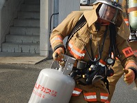写真:隊員が模擬火災建物から危険物品を排除している様子